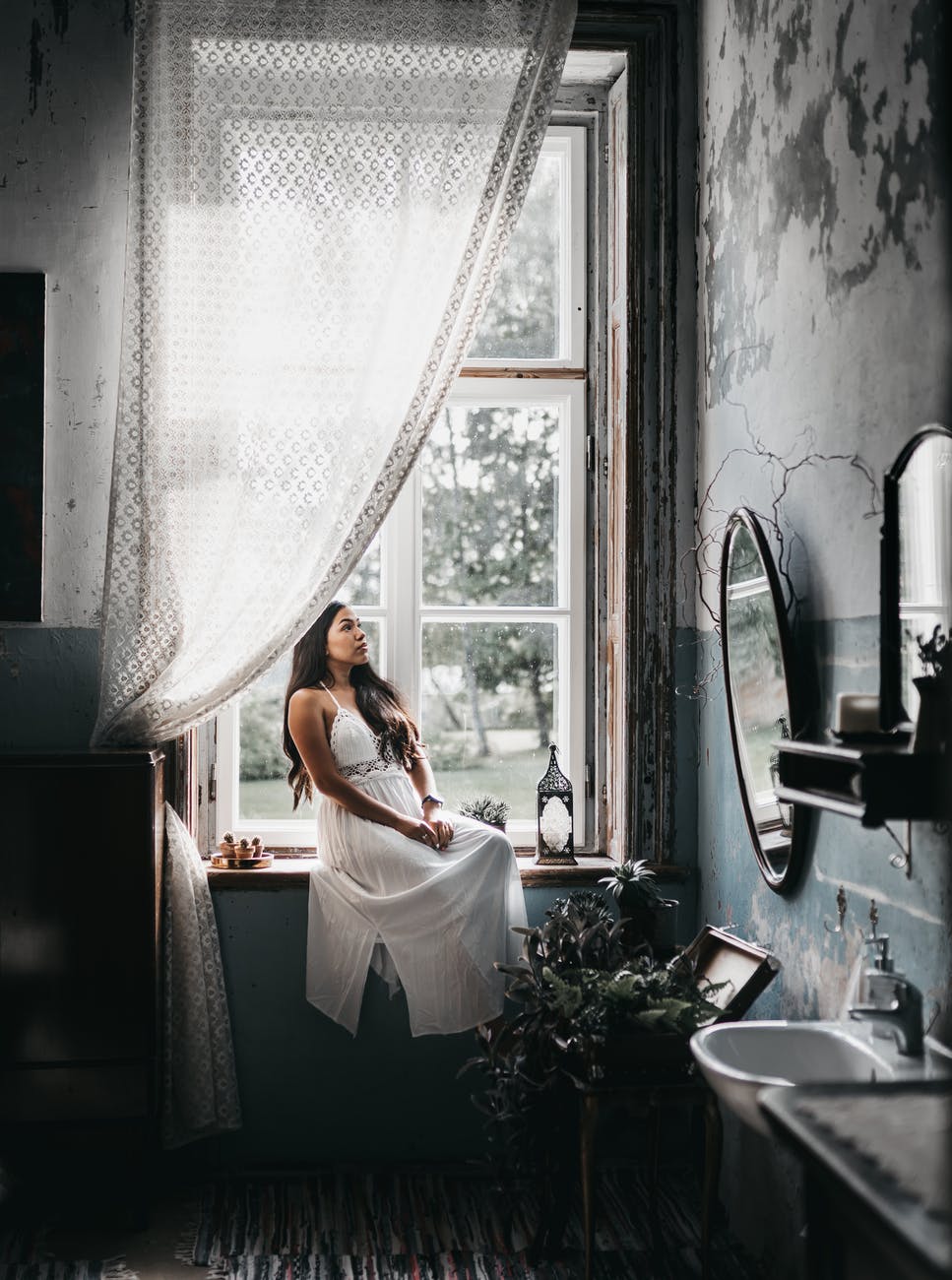charming woman resting on windowsill in shabby bathroom