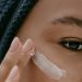 woman applying facial cream on face